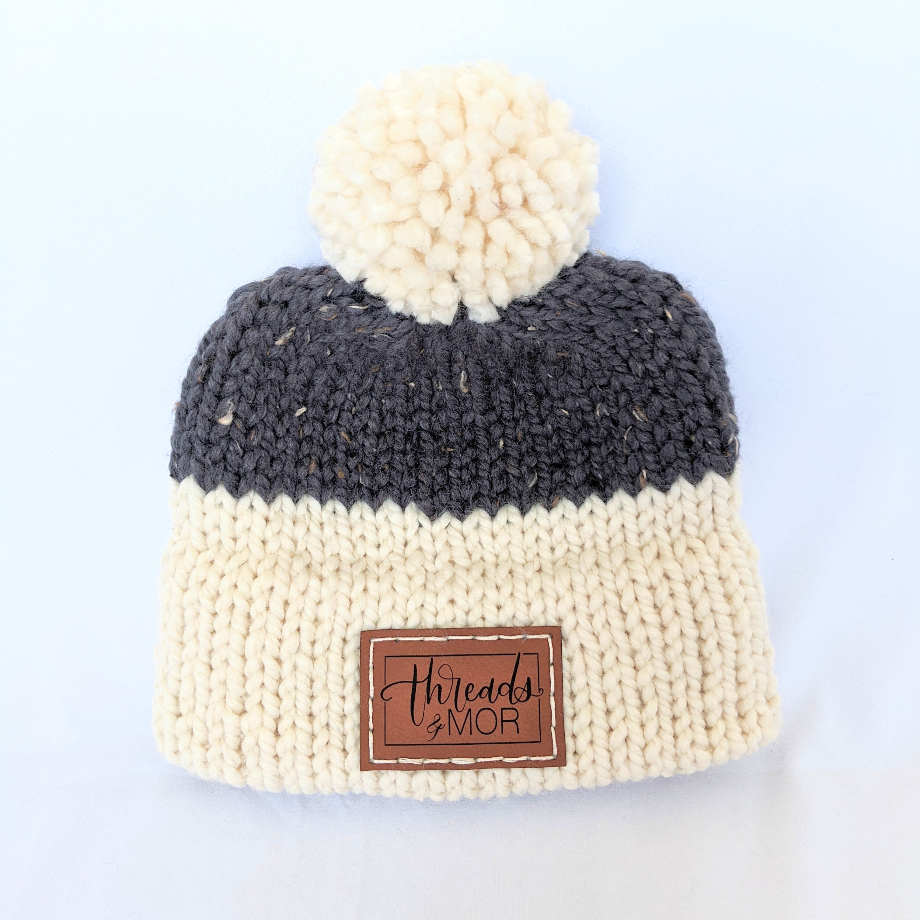 Gray and cream double brim knit hat with yarn pompom