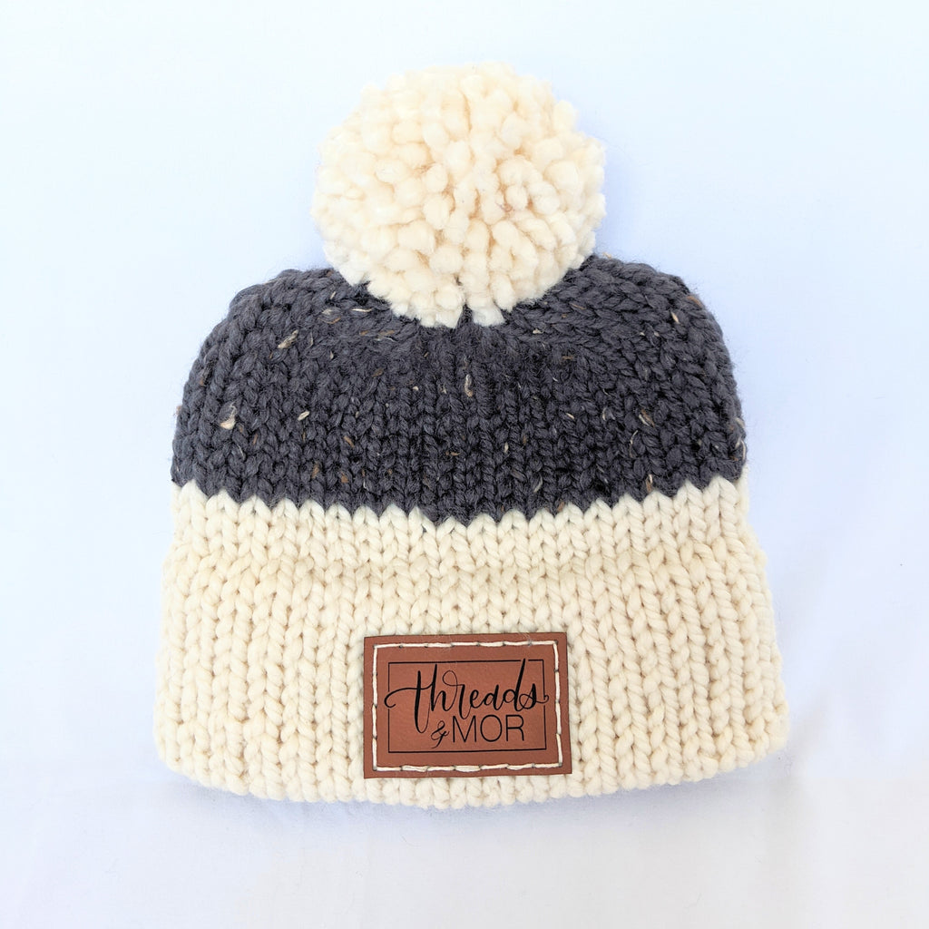 Gray and cream double brim knit hat with yarn pompom