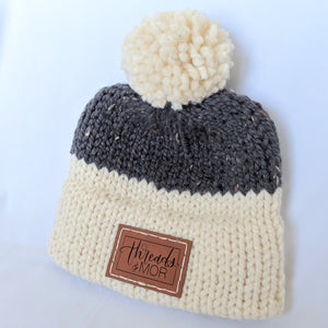 Gray and cream double brim knit hat with yarn pompom